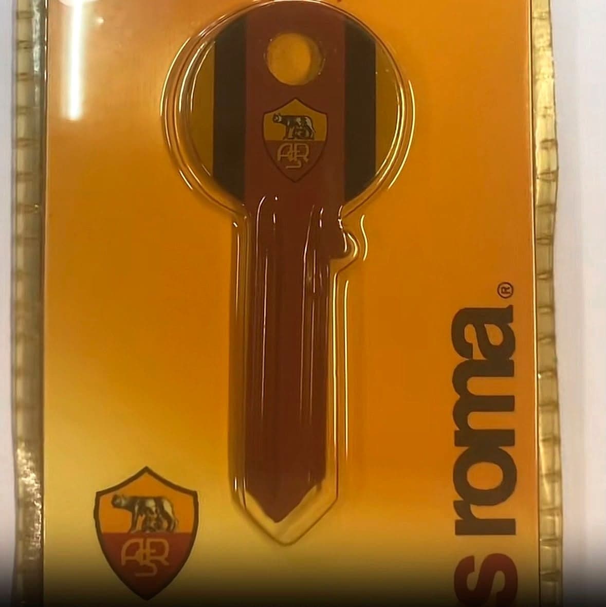 Una chiave grezza con lo stemma e i colori della Roma, nella sua confezione
